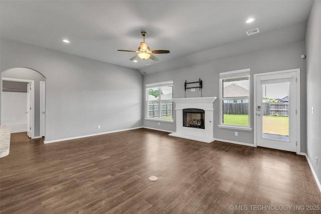 2012 W Huntsville Pl, Broken Arrow, OK 74011 - unfurnished living room featuring ceiling fan, dark wood-style flooring, arched walkways, a fireplace with raised hearth, and recessed lighting