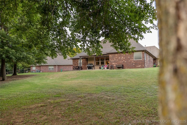 14701 E 150th St, Collinsville, OK 74021 - rear view of property featuring brick siding, a lawn, a patio area, and a shingled roof