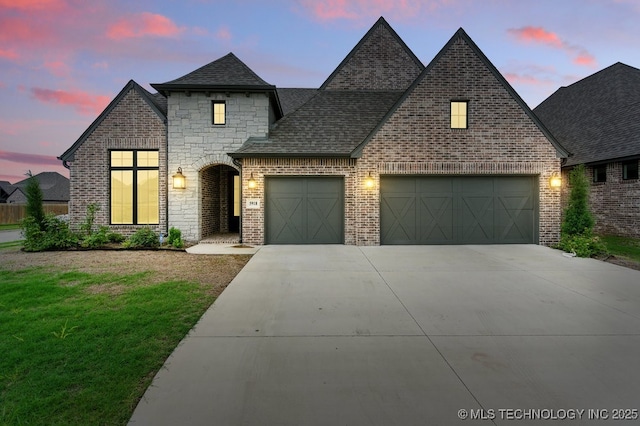 5918 E 126th Pl S, Bixby, OK 74008 - french country home with a garage, driveway, a shingled roof, a front lawn, and stone siding
