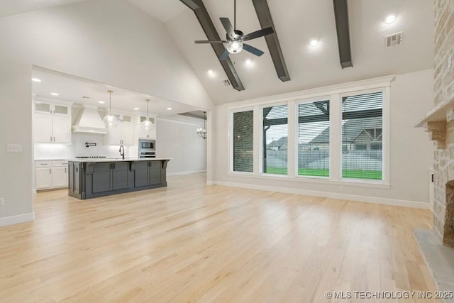 5918 E 126th Pl S, Bixby, OK 74008 - unfurnished living room featuring a stone fireplace, high vaulted ceiling, ceiling fan, beamed ceiling, and light wood-style floors