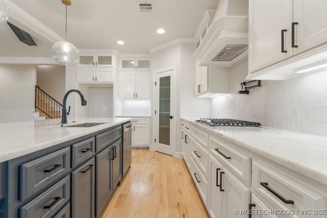 5918 E 126th Pl S, Bixby, OK 74008 - kitchen featuring custom range hood, appliances with stainless steel finishes, white cabinetry, glass insert cabinets, and light wood-style flooring