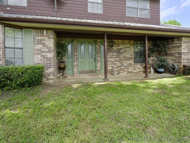 311 Washington Ave, Boswell, OK 74727 - entrance to property featuring brick siding, a lawn, and a metal roof