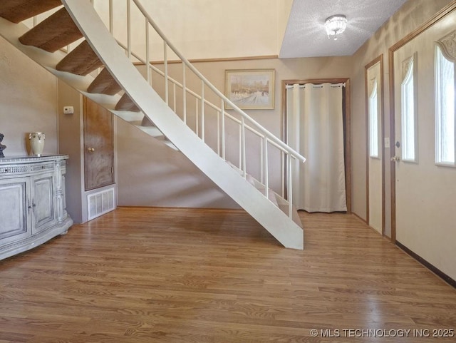 311 Washington Ave, Boswell, OK 74727 - foyer with stairway, wood finished floors, and a textured ceiling