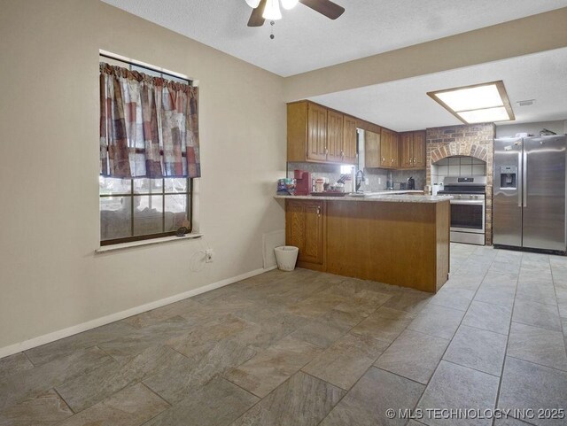 311 Washington Ave, Boswell, OK 74727 - kitchen with stainless steel appliances, ceiling fan, a peninsula, brown cabinetry, and backsplash