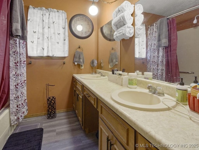311 Washington Ave, Boswell, OK 74727 - bathroom featuring double vanity, wood finished floors, and shower / bath combo with shower curtain