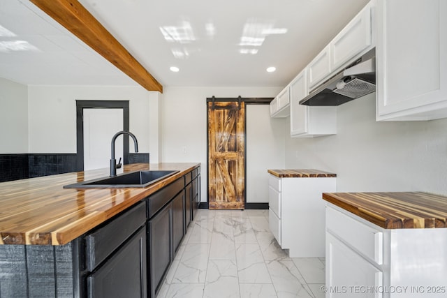 1119 W 7th St, Okmulgee, OK 74447 - kitchen featuring wood counters, a barn door, under cabinet range hood, light marble finish flooring, and recessed lighting
