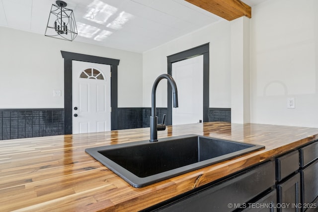 1119 W 7th St, Okmulgee, OK 74447 - kitchen featuring wooden counters, wainscoting, and pendant lighting