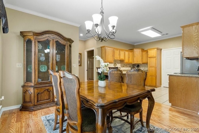 8306 E 77th Pl, Tulsa, OK 74133 - dining area featuring light wood finished floors, a chandelier, and ornamental molding