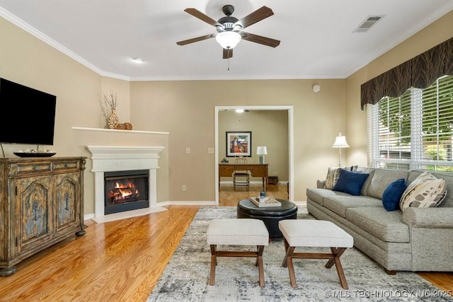 8306 E 77th Pl, Tulsa, OK 74133 - living area with light wood-type flooring, ornamental molding, ceiling fan, and a glass covered fireplace