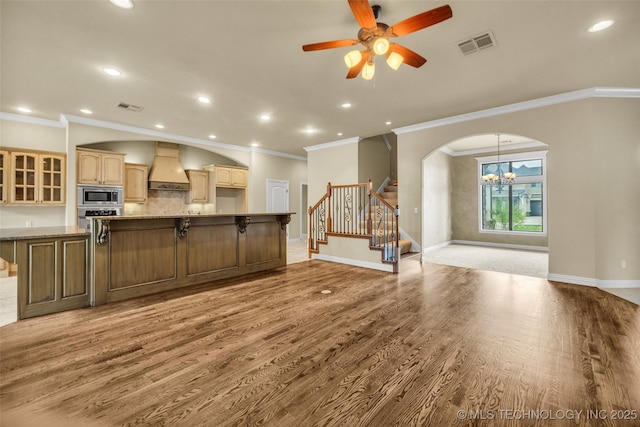 14651 S Gary Ave, Bixby, OK 74008 - kitchen with appliances with stainless steel finishes, premium range hood, ornamental molding, a ceiling fan, and light wood-style flooring