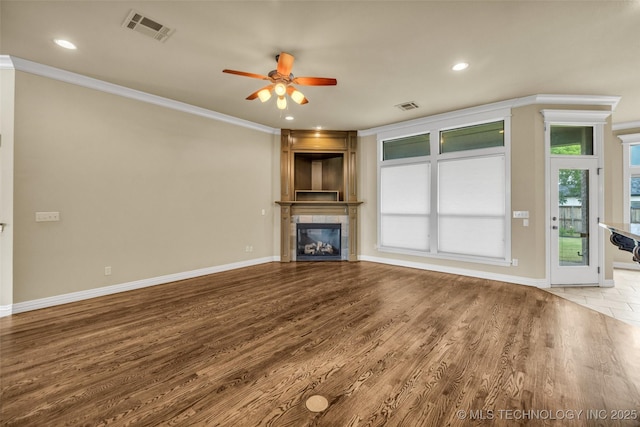 14651 S Gary Ave, Bixby, OK 74008 - unfurnished living room with ornamental molding, a tiled fireplace, a ceiling fan, recessed lighting, and wood finished floors