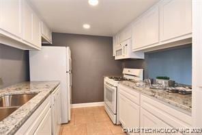 410 W 7th St Unit 224, Tulsa, OK 74119 - kitchen featuring white appliances, white cabinetry, recessed lighting, and light stone countertops