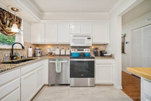 5612 S Newport Ave Unit 5612, Tulsa, OK 74105 - kitchen featuring stainless steel appliances, white cabinetry, light stone counters, ornamental molding, and backsplash