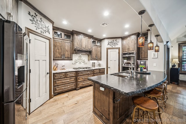 3818 W Phoenix Pl, Broken Arrow, OK 74011 - kitchen featuring stainless steel appliances, light wood finished floors, decorative backsplash, a breakfast bar area, and glass insert cabinets