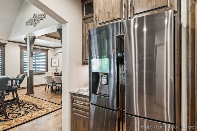 3818 W Phoenix Pl, Broken Arrow, OK 74011 - kitchen featuring stainless steel fridge, ornate columns, light wood-type flooring, arched walkways, and light stone counters