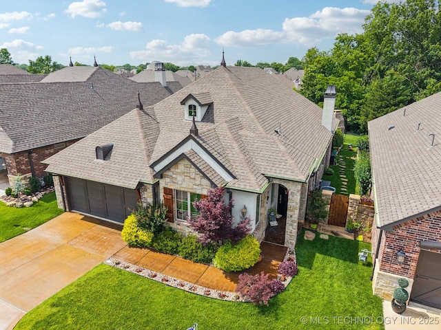 3818 W Phoenix Pl, Broken Arrow, OK 74011 - french country home with stone siding, a shingled roof, concrete driveway, a chimney, and an attached garage