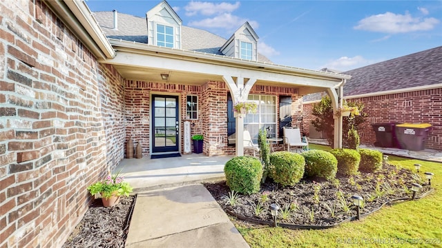 1010 W 120th St, Jenks, OK 74037 - doorway to property featuring a porch, brick siding, and roof with shingles