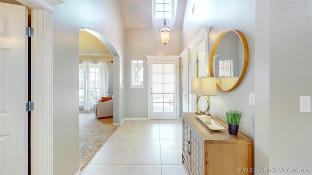 1010 W 120th St, Jenks, OK 74037 - foyer with arched walkways, a towering ceiling, light tile patterned floors, and light colored carpet