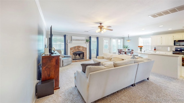 1010 W 120th St, Jenks, OK 74037 - living area featuring a ceiling fan, ornamental molding, a fireplace, recessed lighting, and light carpet