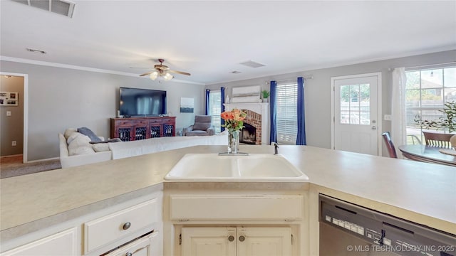 1010 W 120th St, Jenks, OK 74037 - kitchen with dishwasher, light countertops, a ceiling fan, ornamental molding, and a brick fireplace