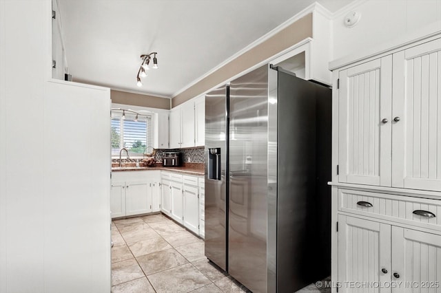 7547 E 27th St, Tulsa, OK 74129 - kitchen featuring stainless steel refrigerator with ice dispenser, crown molding, white cabinetry, and tasteful backsplash