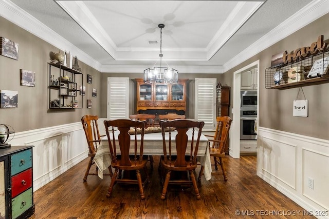 1516 W Trenton St, Broken Arrow, OK 74012 - dining area featuring a tray ceiling, a chandelier, dark wood-type flooring, a wainscoted wall, and a decorative wall