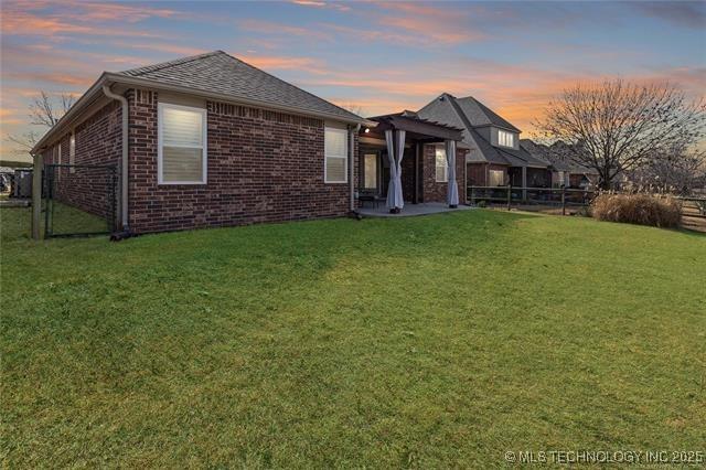 1516 W Trenton St, Broken Arrow, OK 74012 - back of house featuring brick siding and a patio area