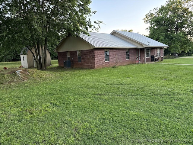 3176 E 2030th Rd, Sawyer, OK 74756 - view of side of home with a shed, brick siding, a yard, and a metal roof