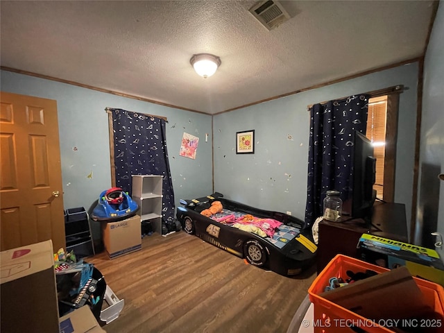 3176 E 2030th Rd, Sawyer, OK 74756 - bedroom featuring wood finished floors, a textured ceiling, and ornamental molding