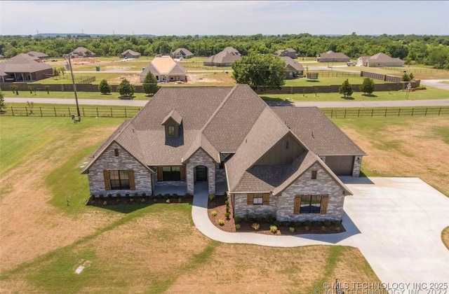 9022 N 65th Pl E, Owasso, OK 74055 - view of front of house featuring stone siding, a garage, and concrete driveway