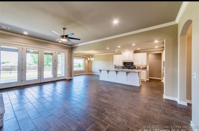 9022 N 65th Pl E, Owasso, OK 74055 - unfurnished living room featuring arched walkways, a ceiling fan, crown molding, recessed lighting, and dark wood-type flooring