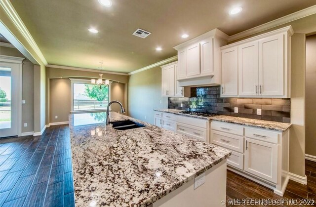 9022 N 65th Pl E, Owasso, OK 74055 - kitchen with ornamental molding, white cabinets, a chandelier, a center island with sink, and recessed lighting