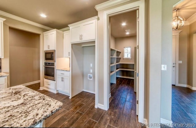 9022 N 65th Pl E, Owasso, OK 74055 - kitchen with stainless steel oven, black microwave, light stone countertops, dark wood-type flooring, and white cabinetry