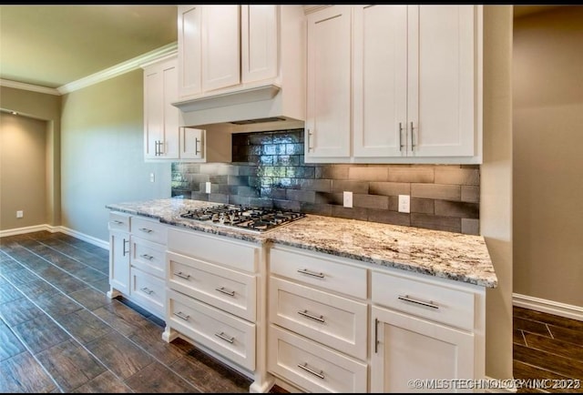 9022 N 65th Pl E, Owasso, OK 74055 - kitchen featuring stainless steel gas stovetop, ornamental molding, backsplash, white cabinetry, and dark wood-style flooring