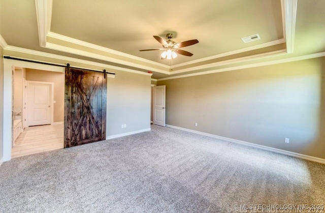9022 N 65th Pl E, Owasso, OK 74055 - unfurnished bedroom featuring a raised ceiling, crown molding, carpet floors, a barn door, and a ceiling fan