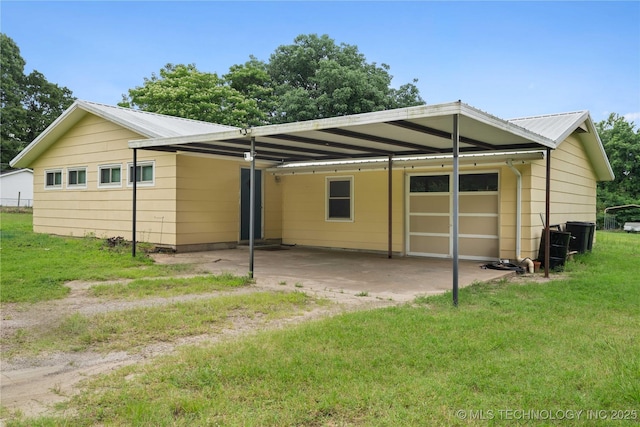 417530 E 1140th Rd, Checotah, OK 74426 - back of house with a lawn, a metal roof, a carport, and a garage