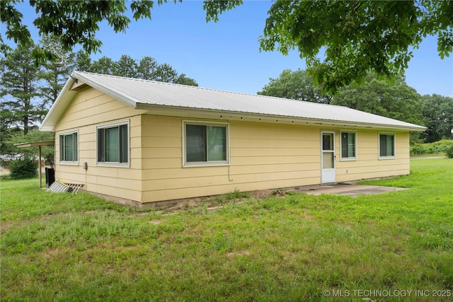 417530 E 1140th Rd, Checotah, OK 74426 - back of house featuring a metal roof, a lawn, and a patio