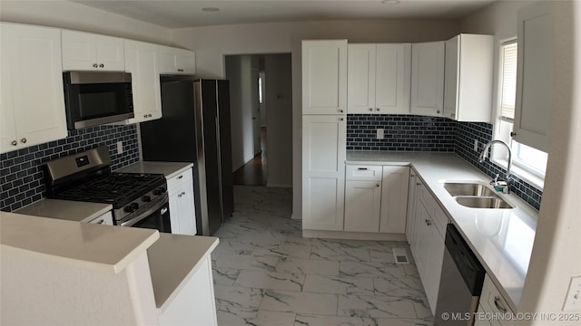 5921 S Sandusky Ave, Tulsa, OK 74135 - kitchen featuring appliances with stainless steel finishes, light marble finish flooring, and white cabinets