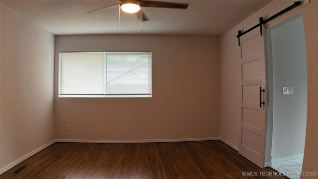 5921 S Sandusky Ave, Tulsa, OK 74135 - empty room with a barn door, dark wood-type flooring, and ceiling fan