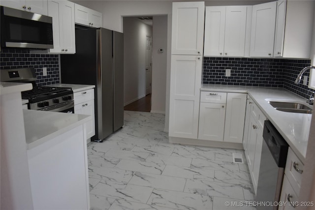 5921 S Sandusky Ave, Tulsa, OK 74135 - kitchen featuring appliances with stainless steel finishes, light marble finish floors, white cabinetry, and light countertops
