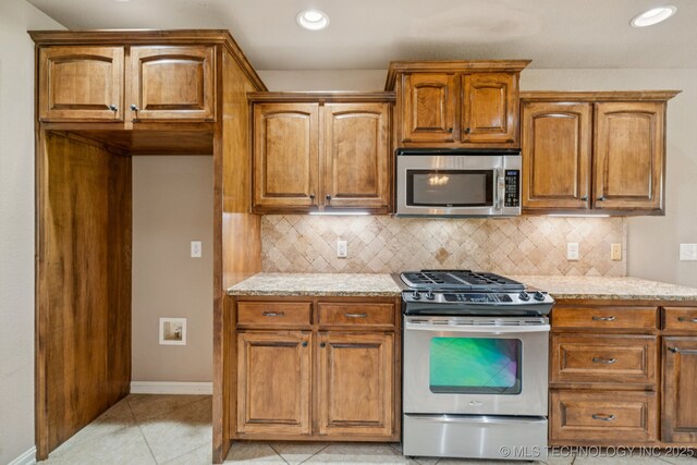 9200 E 92nd Pl, Owasso, OK 74055 - kitchen featuring appliances with stainless steel finishes, light stone counters, tasteful backsplash, and recessed lighting
