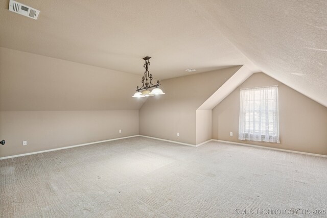 9200 E 92nd Pl, Owasso, OK 74055 - additional living space with vaulted ceiling, carpet, and a textured ceiling