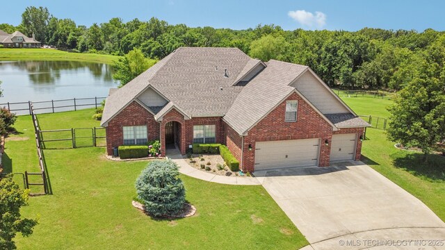 9200 E 92nd Pl, Owasso, OK 74055 - view of front of property with brick siding, driveway, a water view, roof with shingles, and a garage