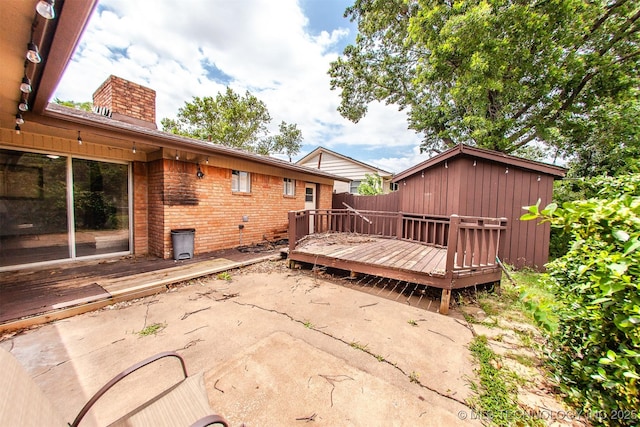 7025 E 58th Pl, Tulsa, OK 74145 - rear view of property with brick siding, a wooden deck, a chimney, and a patio