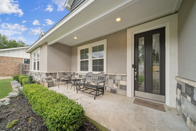 1909 W Nashville St, Broken Arrow, OK 74012 - doorway to property with stone siding, stucco siding, and covered porch
