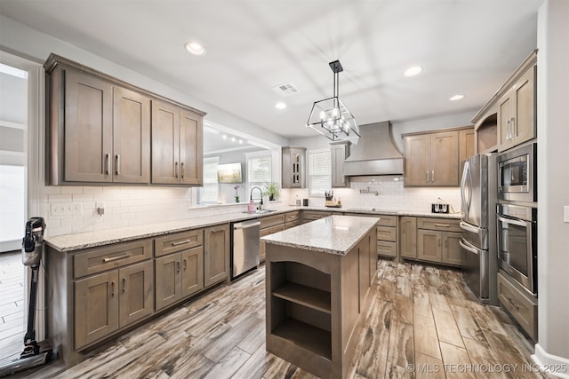 1909 W Nashville St, Broken Arrow, OK 74012 - kitchen featuring custom exhaust hood, stainless steel appliances, open shelves, a kitchen island, and light stone countertops