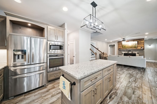 1909 W Nashville St, Broken Arrow, OK 74012 - kitchen with stainless steel appliances, wood finished floors, open shelves, recessed lighting, and a center island