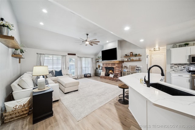 1112 N Yellowood Ave, Broken Arrow, OK 74012 - living area with vaulted ceiling, ceiling fan, a fireplace, light wood finished floors, and recessed lighting