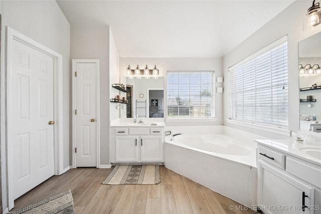 1112 N Yellowood Ave, Broken Arrow, OK 74012 - full bath featuring a garden tub, two vanities, lofted ceiling, and wood finished floors