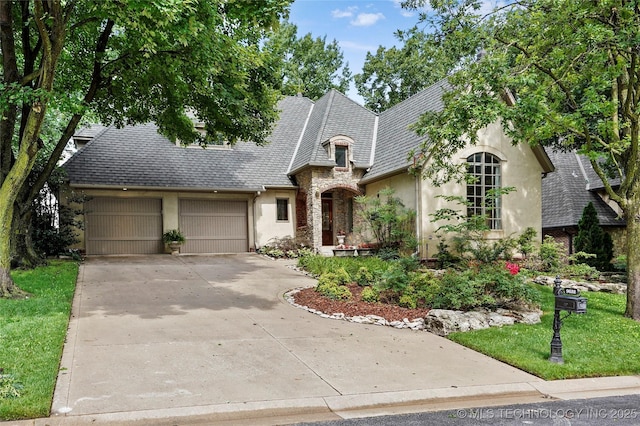 9632 S Vandalia Ave, Tulsa, OK 74137 - french country inspired facade featuring stucco siding, a garage, concrete driveway, and stone siding